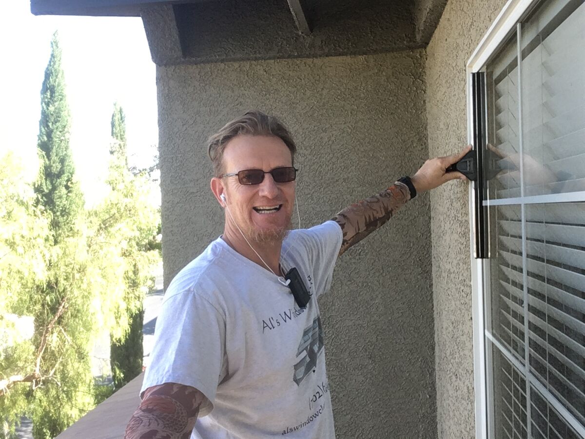 Al, the owner, squeegeeing a home window in his Al’s Window Cleaning shirt