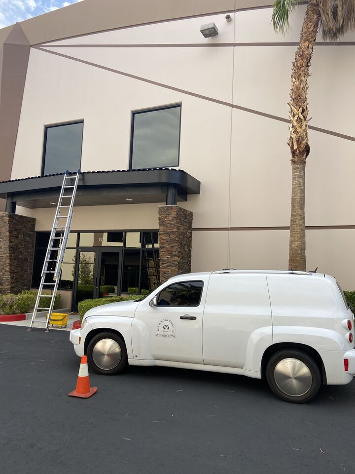 Al’s white van and ladder set up at a commercial building